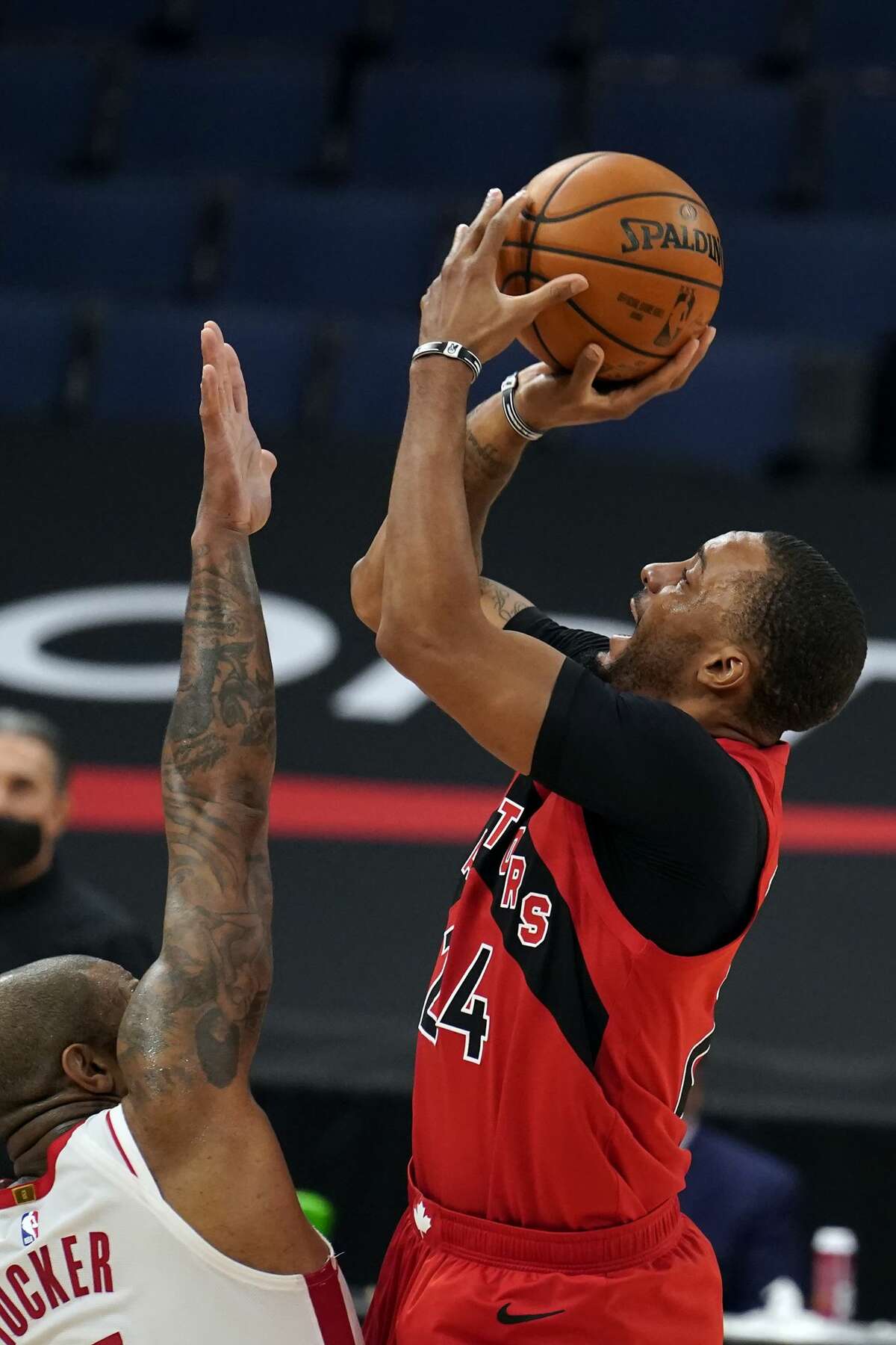 Toronto Raptors guard Norman Powell (24) shoots over Houston Rockets forward P.J. Tucker (17) during the first half of an NBA basketball game Friday, Feb. 26, 2021, in Tampa, Fla. (AP Photo/Chris O'Meara)