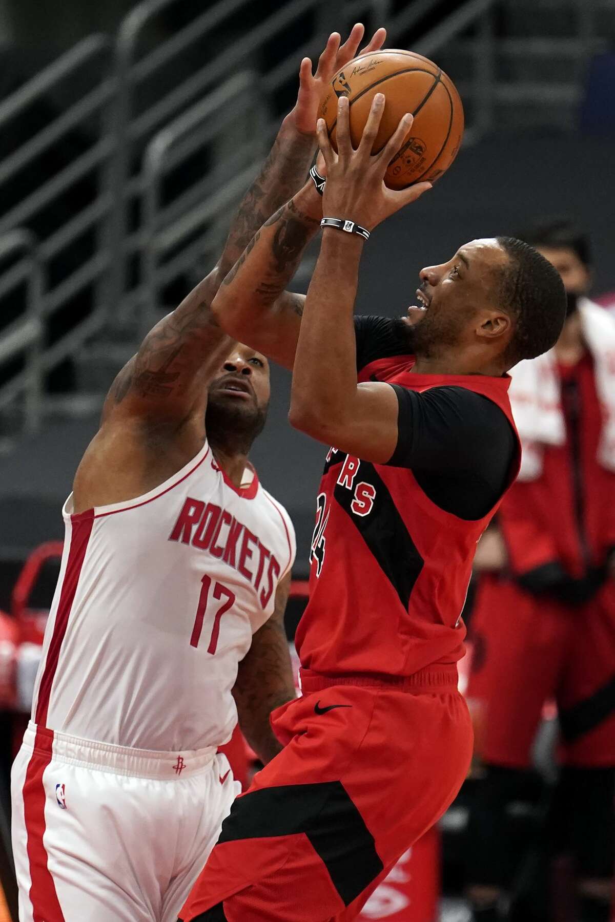Toronto Raptors guard Norman Powell (24) shoots against Houston Rockets forward P.J. Tucker (17) during the first half of an NBA basketball game Friday, Feb. 26, 2021, in Tampa, Fla. (AP Photo/Chris O'Meara)