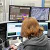Veteran emergency dispatcher Lynn Erazmus works in front of a bank of screens in the Emergency Communications Center in Fairfield in 2018.