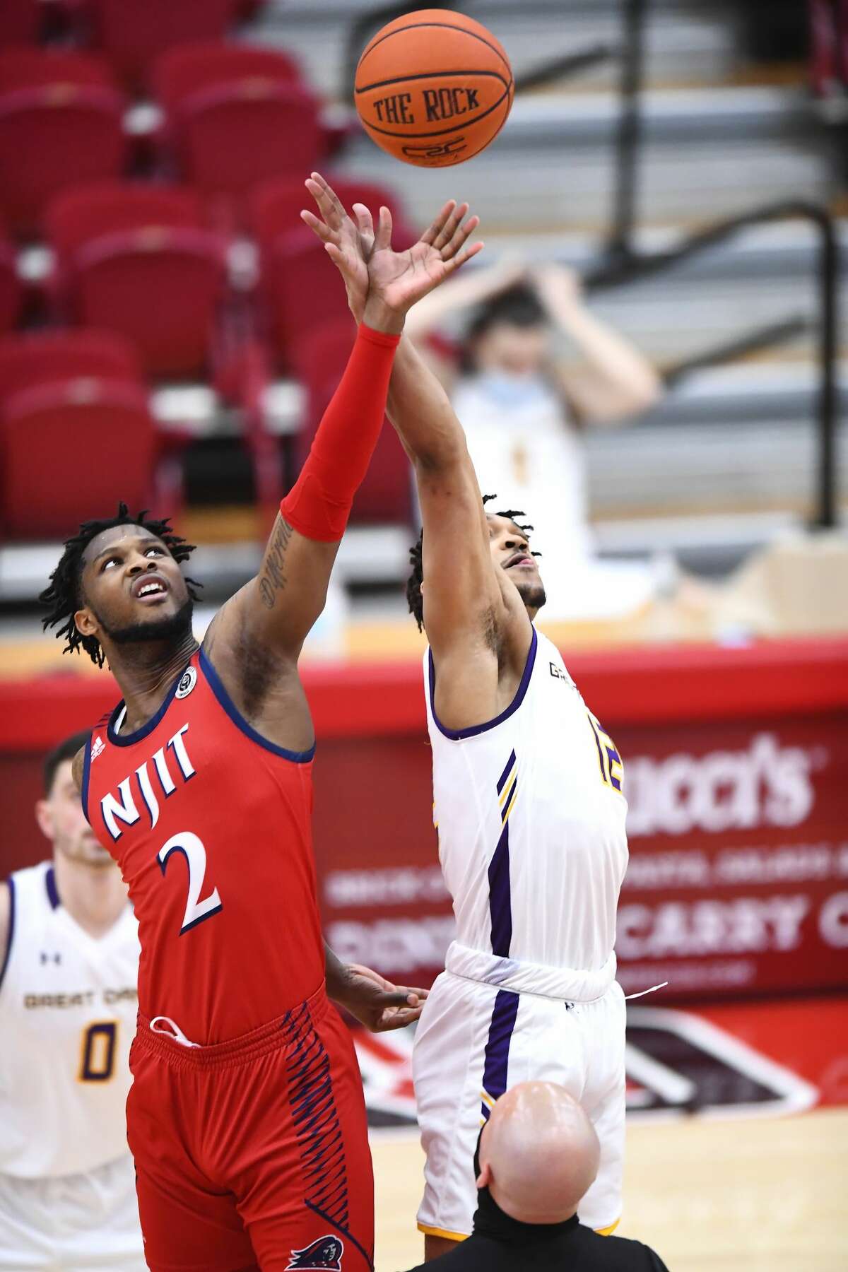 NJIT's San Antonio Brinson (2) and UAlbany's Kellon Taylor battle for the opening tip in an America East Tournament basketball game Saturday, Feb. 27, 2021, in Hartford, Conn. UAlbany won, 76-66. (Steve McLaughlin/Hartford Athletics)