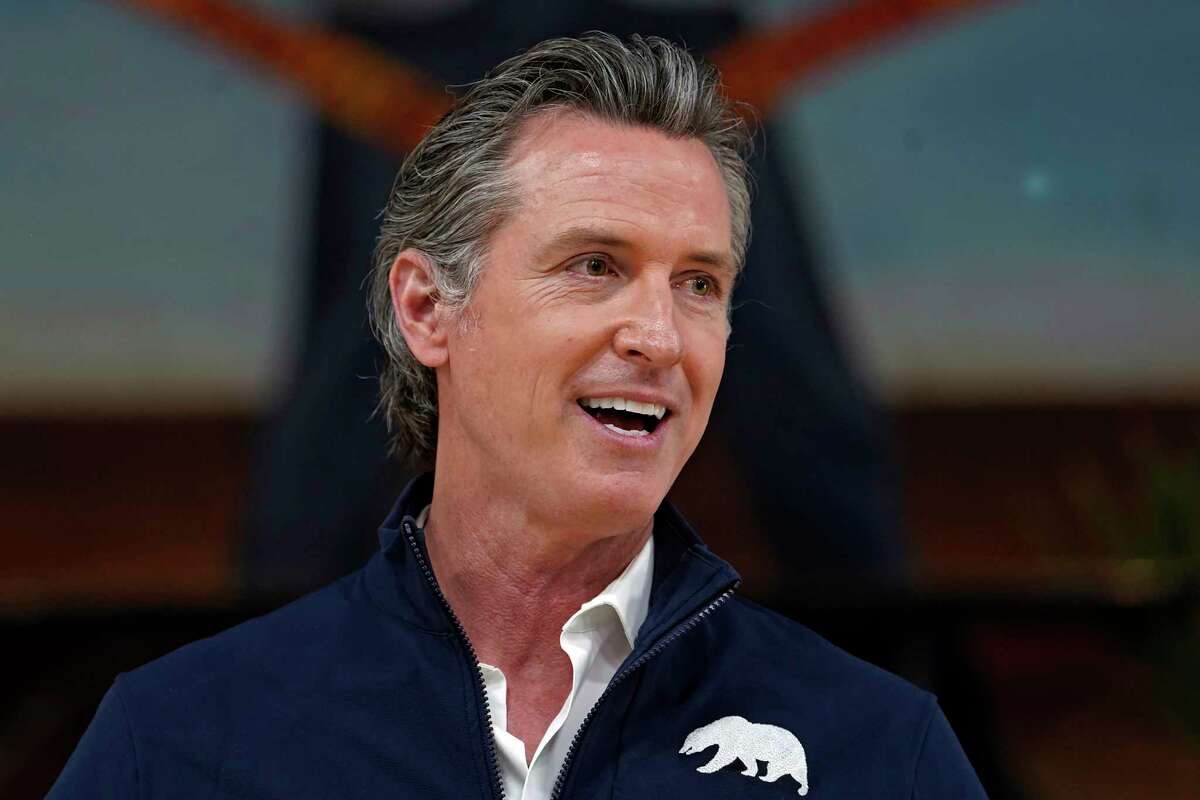 DOSSIER - Sur cette photo d'archive du 21 février 2021, le gouverneur de Californie Gavin Newsom répond aux questions des médias lors d'une visite sur un site de vaccination mobile au Ramona Gardens Recreation Center à Los Angeles.