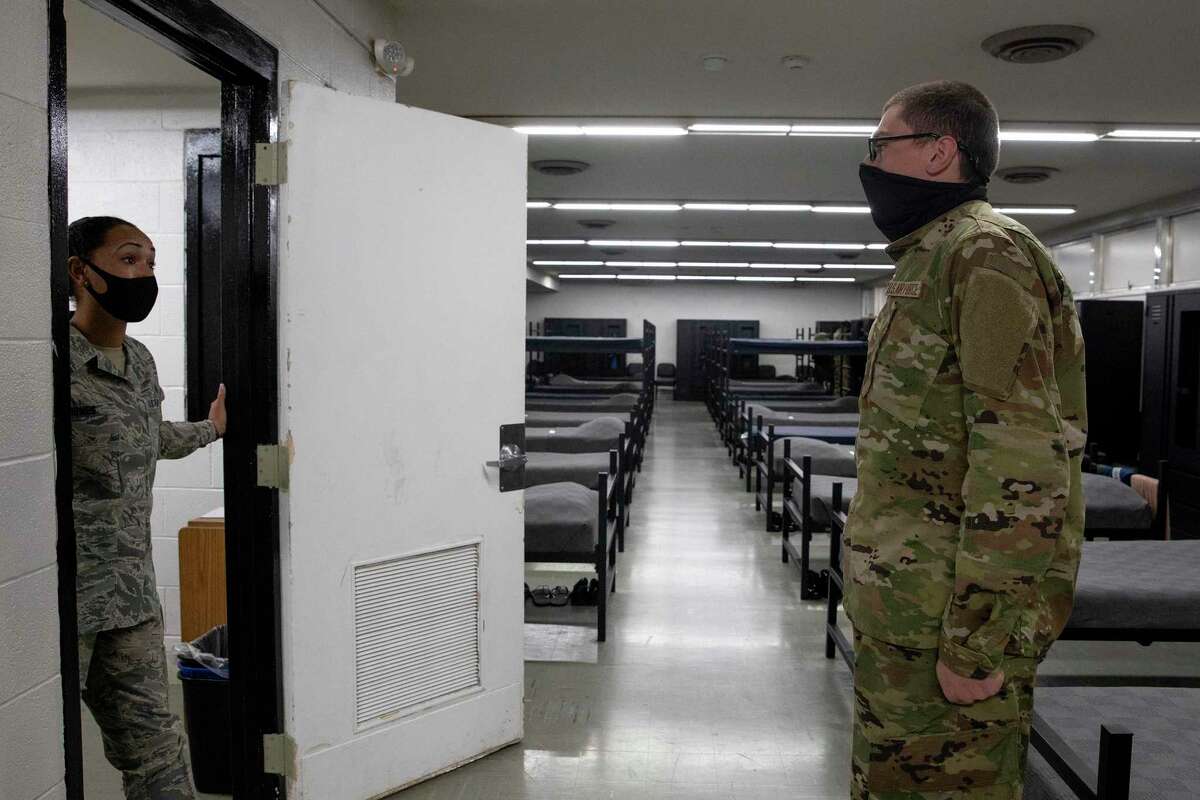 Tech Sgt. Mikesha Jones speaks with a trainee in a dorm at Joint Base San Antonio-Lackland who did not have his locker organized correctly.