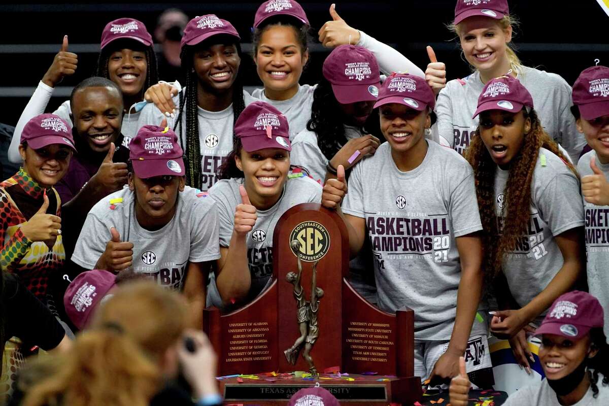 Members of the Texas A&M Aggies women's basketball team pose for photos with the South Eastern Conference regular season trophy after beating South Carolina 65-57 an NCAA college basketball game Sunday, Feb. 28, 2021, in College Station, Texas. (AP Photo/Sam Craft)