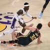 Stephen Curry of the Golden State Warriors falls as he is guarded by Dennis Schroder of the Los Angeles Lakers on Feb. 28, 2021.