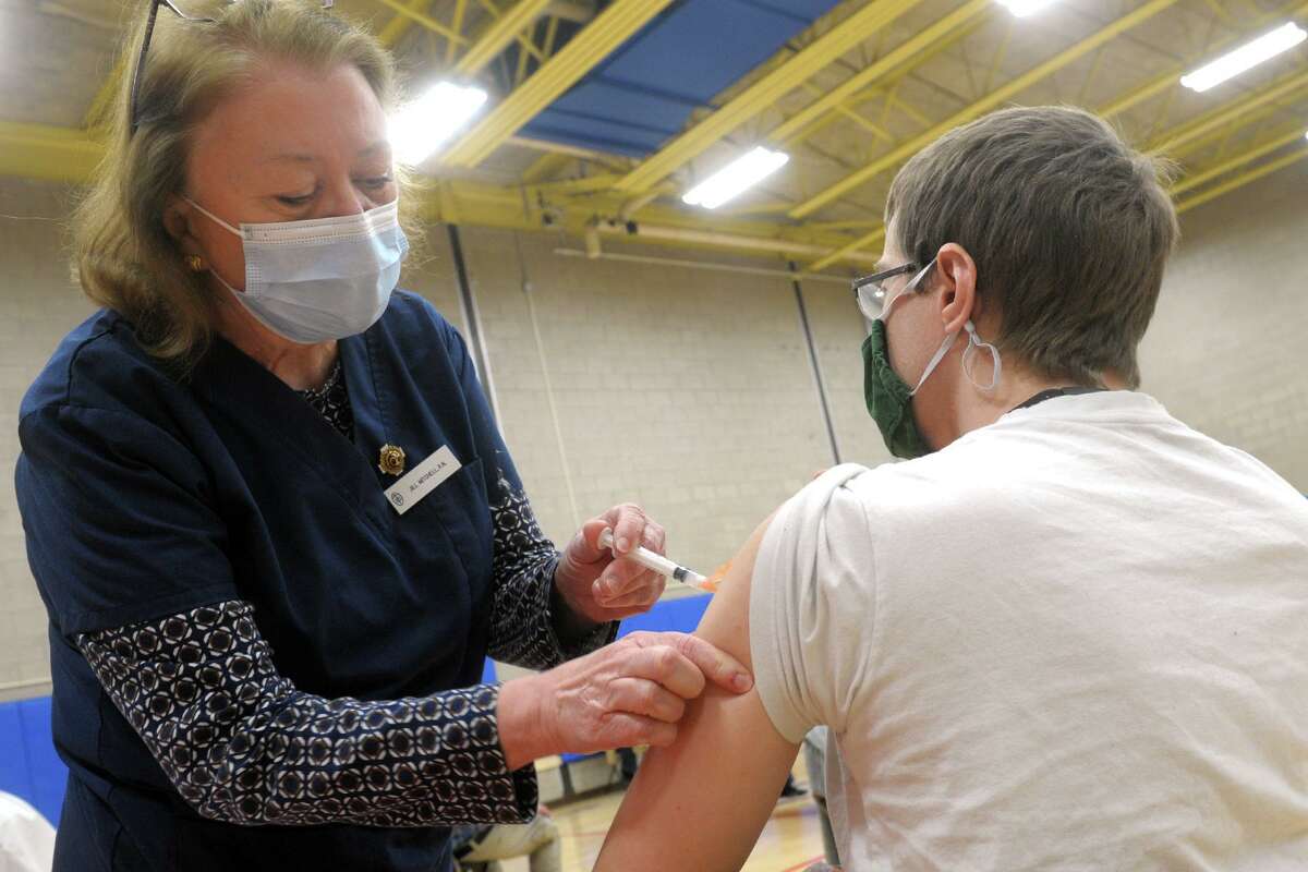 Jill Mitchell, the head nurse administrator for the Town of Fairfield, administers a COVID-19 vaccination to David Kean, a music teacher from Rochambeau Middle School, in Southbury, at the Bigelow Center clinic in Fairfield, Conn. March 1, 2021.