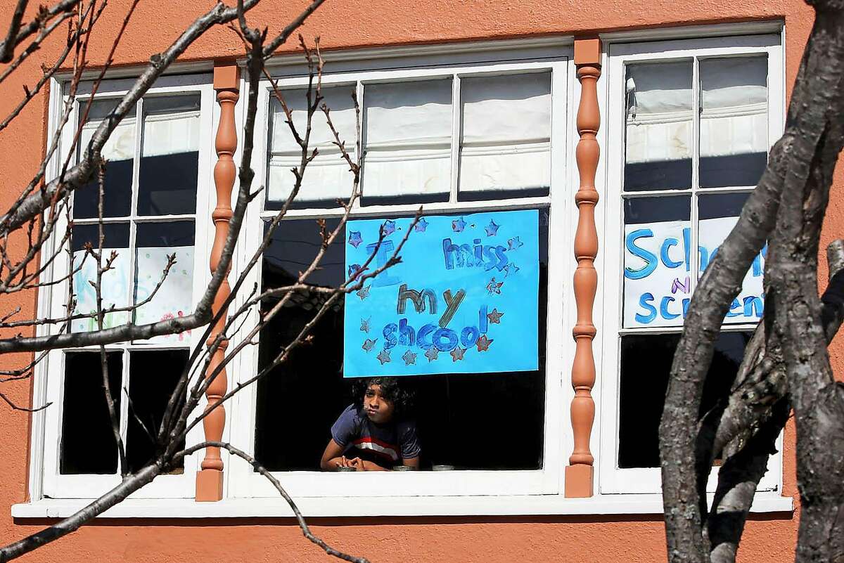 Jeevan Guha dispays the sign he made in a window: “I miss my school.” Jeevan is a first-grader at San Francisco’s West Portal Elementary, away from live school for nearly a year.