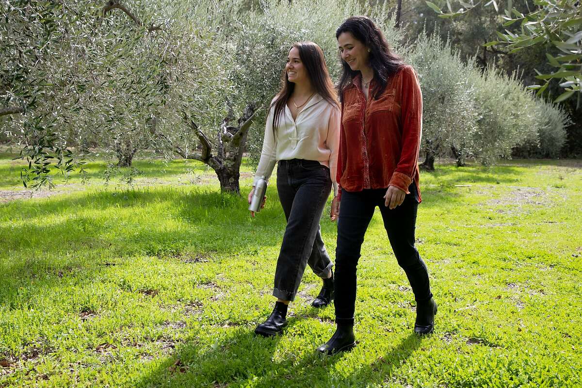 Marcela Hernandez (left) and her mother, Ana Hernandez, walk through an olive grove at their Grove 45 olive oil company in St. Helena.