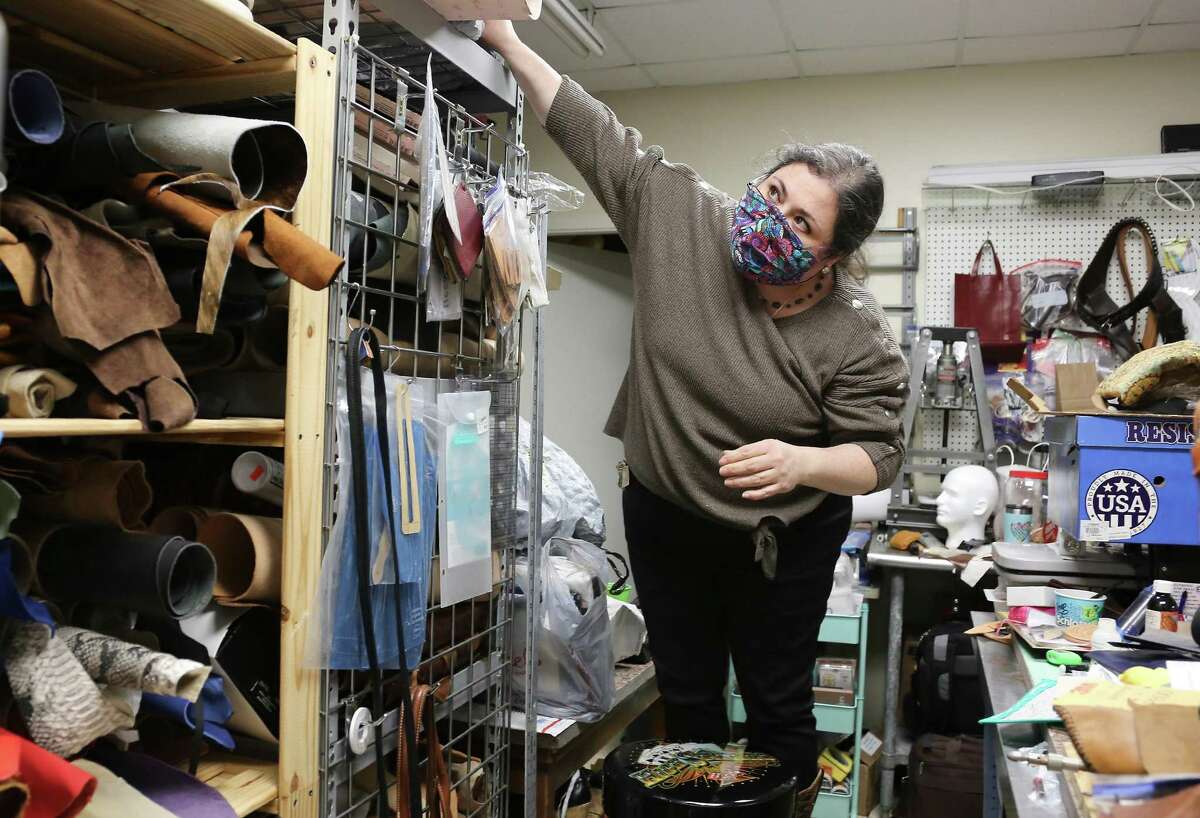 Tania Alejandra, owner of Texas Luxury Goods, works on organizing her down-sized workspace in Houston on Friday, Feb. 5, 2021. Alejandra's landlord let her downsize her space to save money.