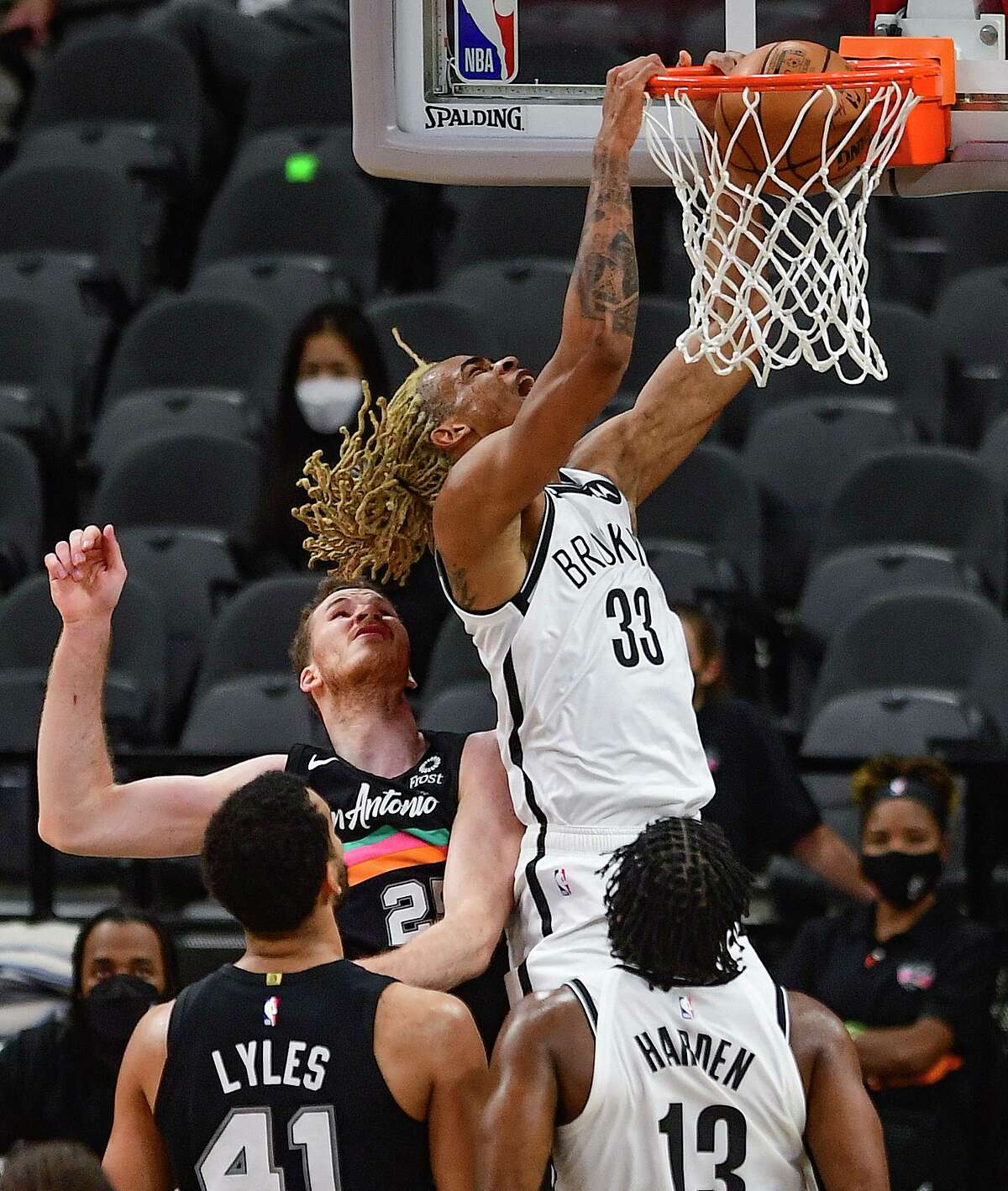 Nicolas Claxton (33) of the Brooklyn Nets dunks over Jakob Poeltl of the San Antonio Spurs during first-half NBA action in the AT&T Center on Monday, March 1, 2021.