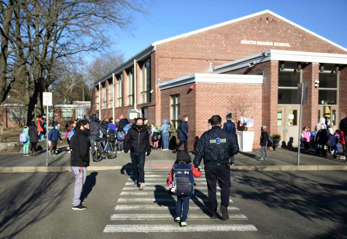 Students enter North Mianus School in the Riverside section of Greenwich, Conn. Tuesday, March 2, 2021. The building needs emergency repairs after a collapsed ceiling and flood.