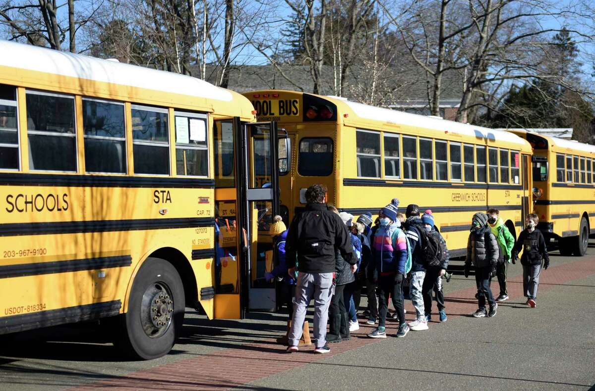 Students board a bus bound for a different school at North Mianus School in the Riverside section of Greenwich, Conn. Tuesday, March 2, 2021. The RTM approved the money for emergency repairs on Thursday night though some students will still have to be relocated when the new school year begins in the fall.