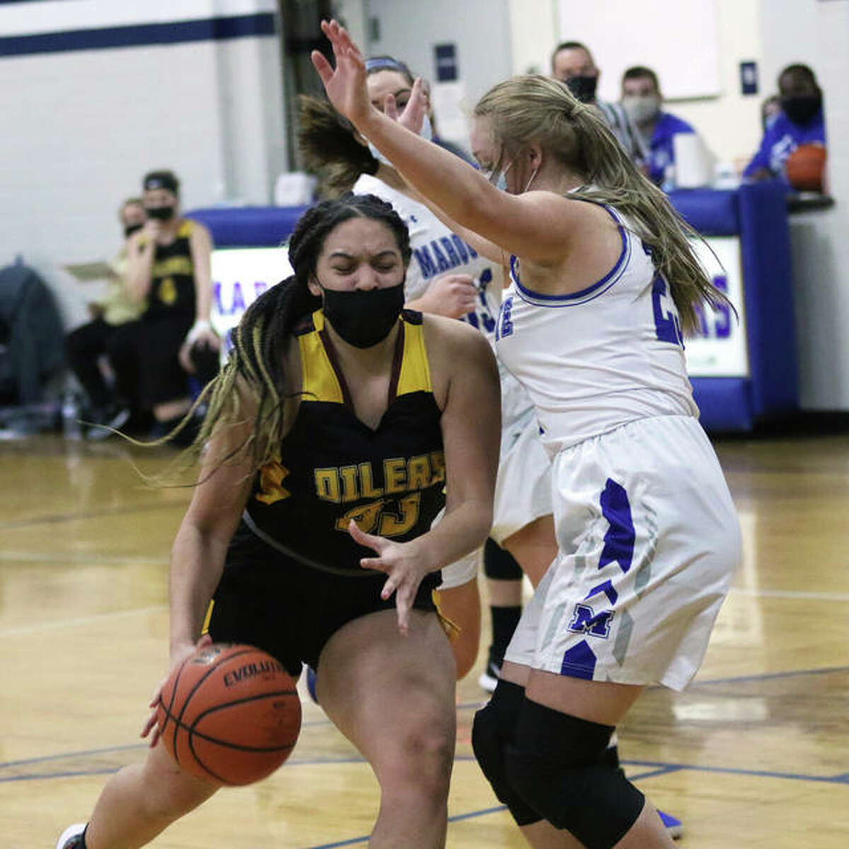 EA-WR’s Emily Johnson (left) drives on a Marquette Catholic defender in a game earlier this season. Johnson, a freshman, had 14 points and 10 rebounds in the Oilers win Monday in Wood River.