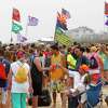 Spring breakers sit on the beach under flags from their universities Thursday, March 17, 2016, at South Padre Island, Texas. (Nathan Lambrecht/The Monitor via AP) MAGS OUT; TV OUT; MANDATORY CREDIT