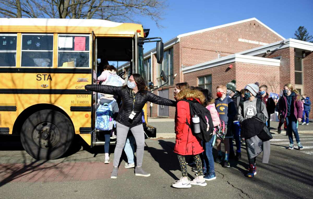 Students board a bus bound for a different school at North Mianus School in the Riverside section of Greenwich, Conn. Tuesday, March 2, 2021. Students returned to in-person learning for the first time since the school flooded on Feb. 13. Certain grades will continue learning in parts of the school deemed safe by the building inspector, while others will be bused to Cos Cob School, Old Greenwich School, and Parkway School.
