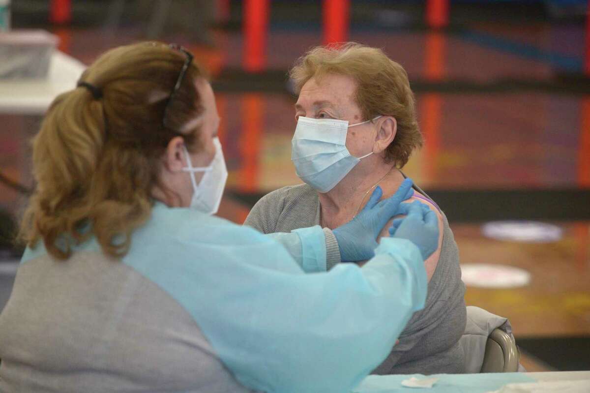 Leslie Purwin LPN, left, with RVNAhealth, administers a COVID-19 vaccine to Doris Conte, of Ridgefield, during the RVNA clinic in the Yanity Gym, Ridgefield, Conn, Thursday, February 4, 2021.