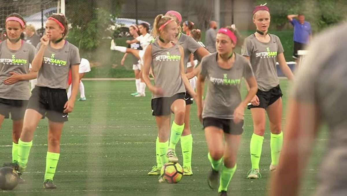 Soccer players with Seton High School in Cincinnati wear the Q-Collar in warmups for a 2018 match, with the concussion alert device developed by Q30 Innovations of Westport, Conn. (Screenshot via YouTube).