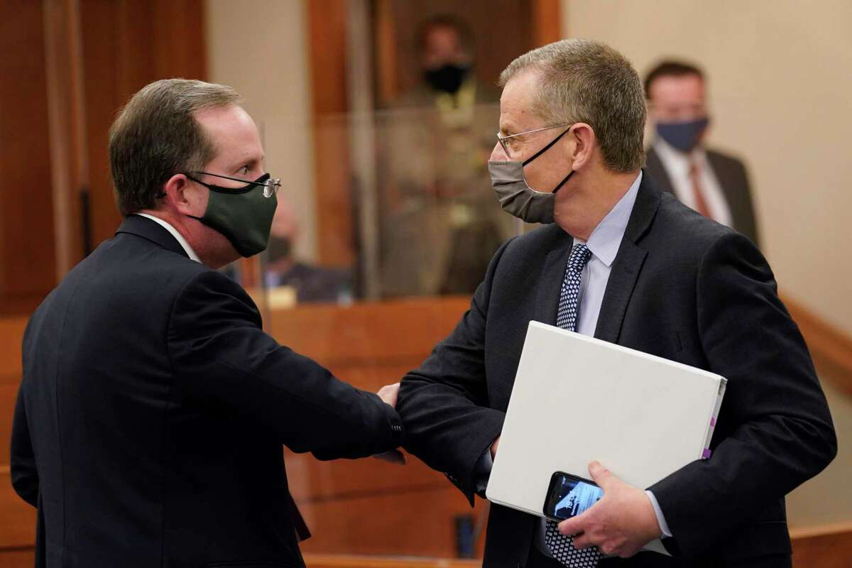 Bill Magness, President and CEO of the Electric Reliability Council of Texas (ERCOT), right, arrives to testify as the Committees on State Affairs and Energy Resources hold a joint public hearing to consider the factors that led to statewide electrical blackouts, Thursday, Feb. 25, 2021, in Austin, Texas. The hearings were the first in Texas since a blackout that was one of the worst in U.S. history, leaving more than 4 million customers without power and heat in subfreezing temperatures. (AP Photo/Eric Gay)