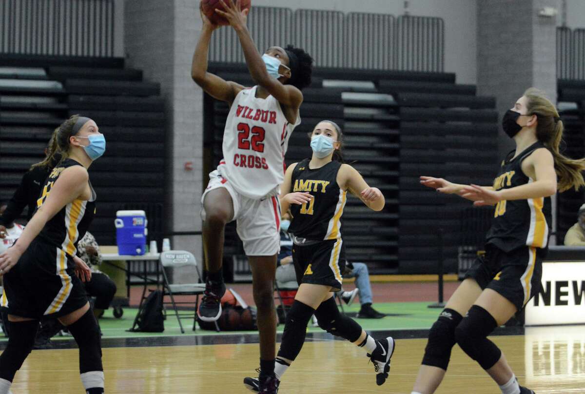 Wilbur Cross’ Dejah Middleton (22) drives to basket past three Amity Regional defenders during a girls basketball game on Tuesday, March 2, 2021 in New Haven, Conn.