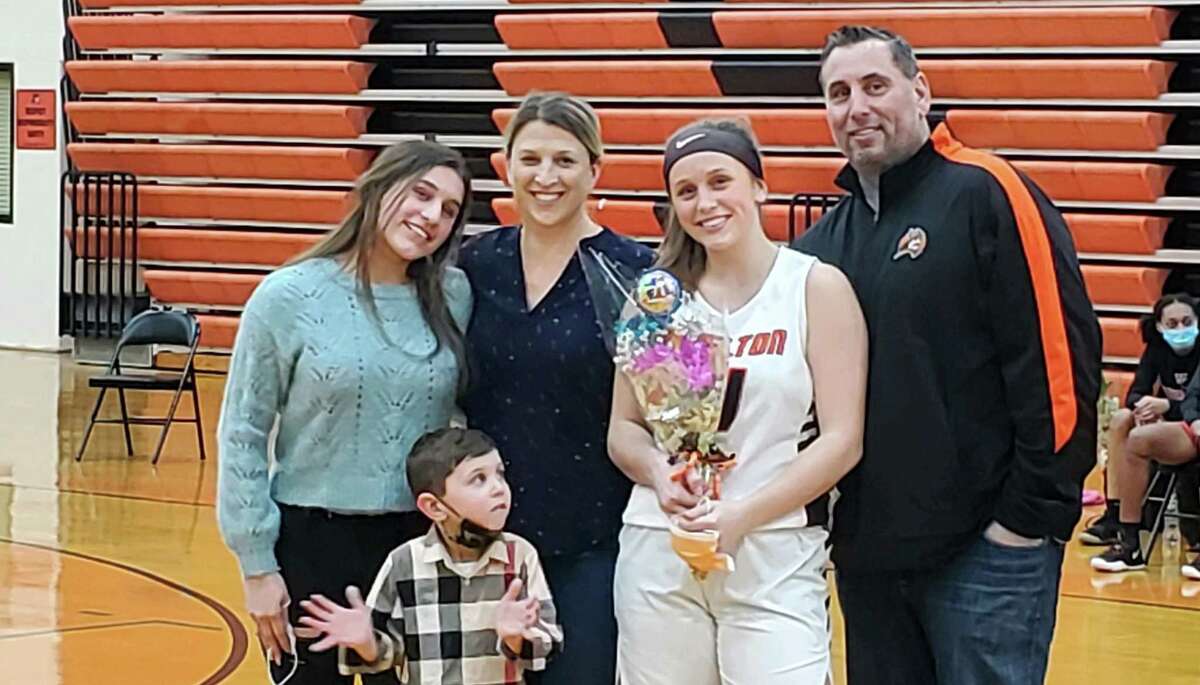 Devan Wildman celebrates Senior Night, and one last basket, with mom Katie, dad Augie, sister Emily and brother Bryce.