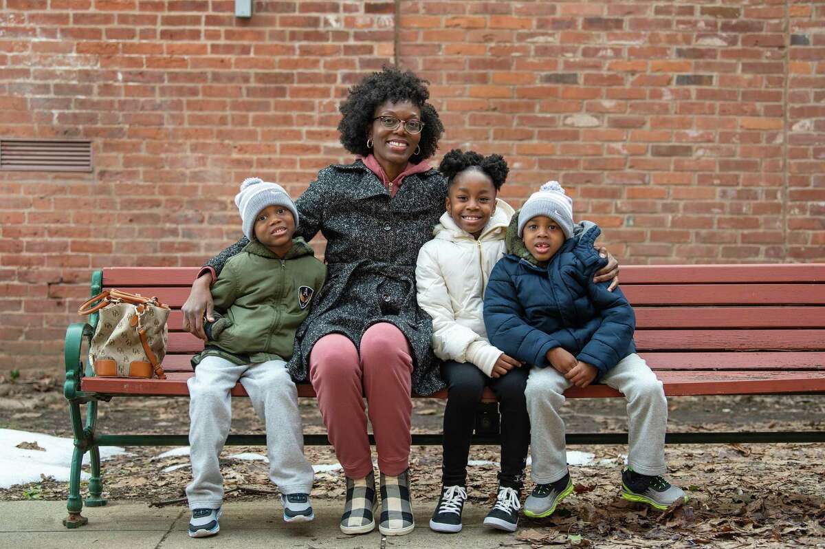 Chinara Johnson is pictured with her children, from left, Zavad Morton, 5, Azania Johnson, 8, and Zakai Morton, 5, near her apartment building in downtown New Haven, Feb. 26, 2021.