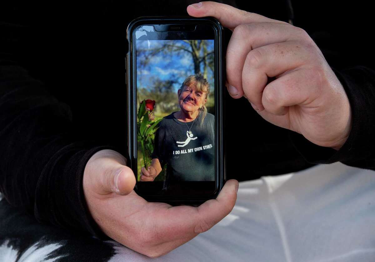 Keaton Clark holds a photograph of his mother, Deann Stephenson, outside his apartment Wednesday, March 3, 2021, in Pasadena, Texas. Stephenson was killed in a dog attack on Feb. 15 while she was walking to the store in Porter, Texas.