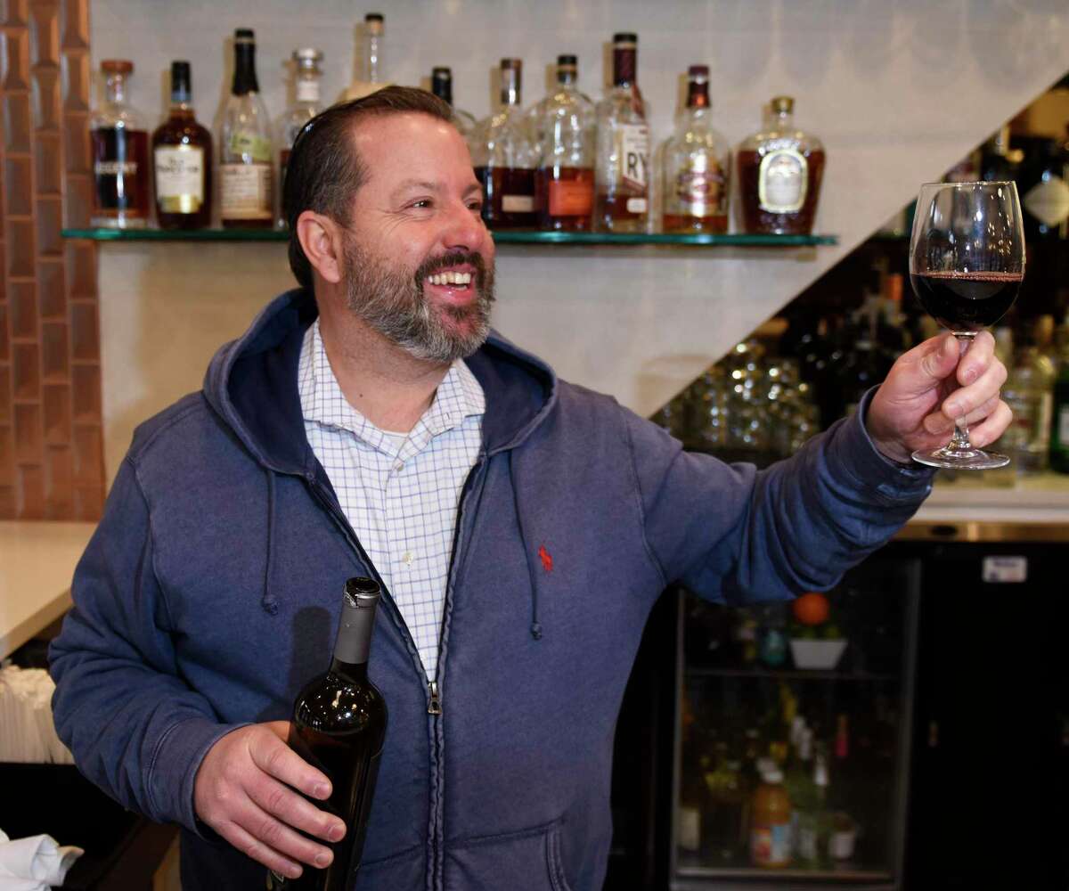 Owner Michael Marchetti cheers to the COVID-19 vaccine at Columbus Park Trattoria in Stamford, Conn. Monday, March 1, 2021. Marchetti says his longtime restaurant regulars in their 70s are returning to dine indoors after getting fully vaccinated and is hopeful it will continue with Connecticut's age group rollouts.