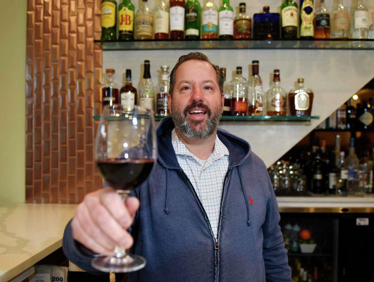 Owner Michael Marchetti cheers to the COVID-19 vaccine at Columbus Park Trattoria in Stamford, Conn. Monday, March 1, 2021. Marchetti says his longtime restaurant regulars in their 70s are returning to dine indoors after getting fully vaccinated and is hopeful it will continue with Connecticut's age group rollouts.