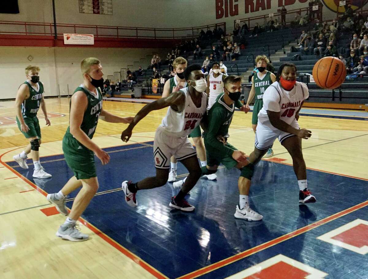 Big Rapids junior Jamal Strickland (left) and senior D.J. GreenBay pursue a ball along the baseline during BR's victory over Central Montcalm on Wednesday night. (Pioneer photo/Joe Judd)