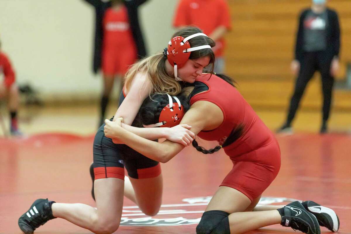 Caney Creek’s Skylar Harris, left, holds down her opponent during a triangular wrestling 110-pound match at Caney Creek High School, Wednesday, March 3, 2021, in Conroe.