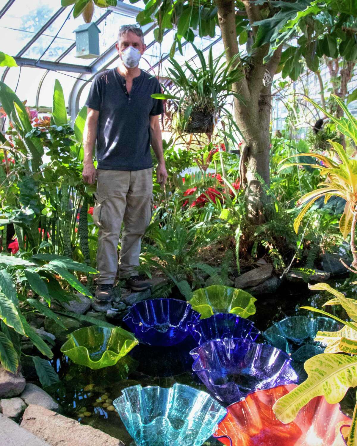 Artist Peter Greenwood sets up his exhibit “DAZZLE: A Garden of Glass” in the greenhouse at Connecticut's Beardsley Zoo in Bridgeport.