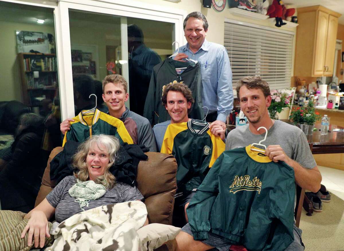 Stephen Piscotty, right, with his brothers Austin, center, and Nick, left, and dad, Mike holding their A's jackets with there mom Gretchen, their home in Pleasanton, Calif., on Monday, January 22, 2018. Piscotty, who was raised in the East Bay a die hard A's fan, was traded from the St. Louis Cardinals to the A's in the offseason, and announced his return with a family photo wearing the jackets they're holding. The move has brought him home an opportune time, as his mother Gretchen was recently diagnosed with ALS.