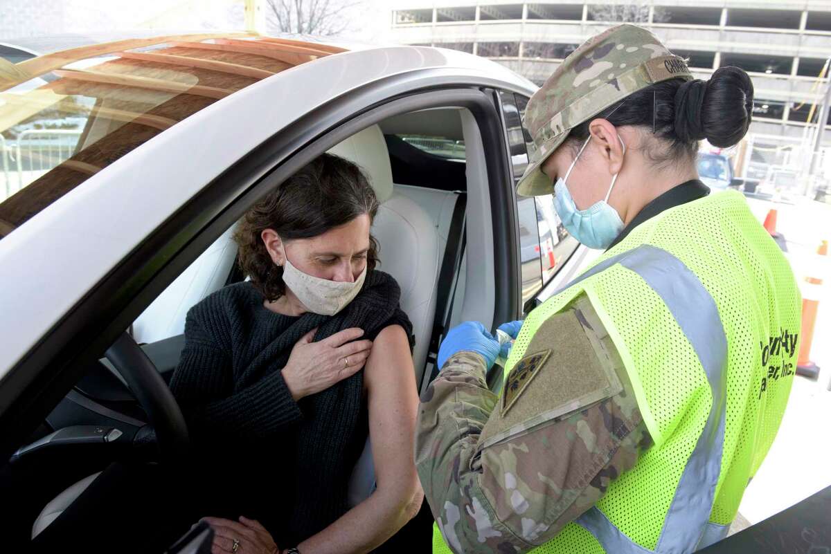 Lauren Cutler, a teacher from Wilton, waits to get her vaccination from PFC Stefanie Charpentier, a medic with the CT National Guard, at Danbury's first mass COVID-19 vaccination site. The Community Health Center, Inc site will utilize six car lanes to serve 600 appointments a day at the Danbury Fair mall. Thursday, March 4, 2021, in Danbury, Conn.