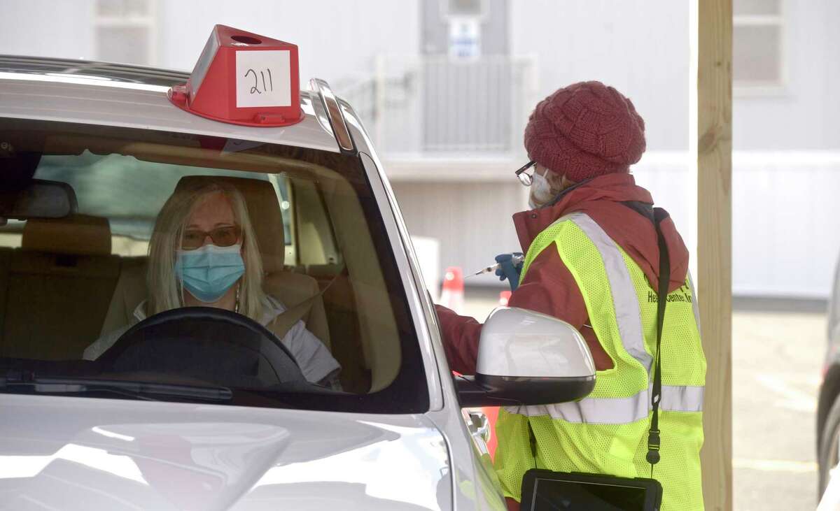 Loretta Foley, of Shelton,, receives a vaccination from Denise Noto, an RN with Danbury Hospital, at Danbury's first mass COVID-19 vaccination site. The Community Health Center, Inc site will utilize six car lanes to serve 600 appointments a day at the Danbury Fair mall. Thursday, March 4, 2021, in Danbury, Conn.