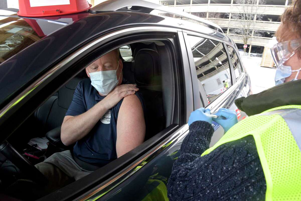 Thomas Kelm, of Bethel, waits to get his vaccination from Nancy Geary, an RN with Danbury Hospital, at Danbury's first mass COVID-19 vaccination site. The Community Health Center, Inc site will utilize six car lanes to serve 600 appointments a day at the Danbury Fair mall. Thursday, March 4, 2021, in Danbury, Conn.