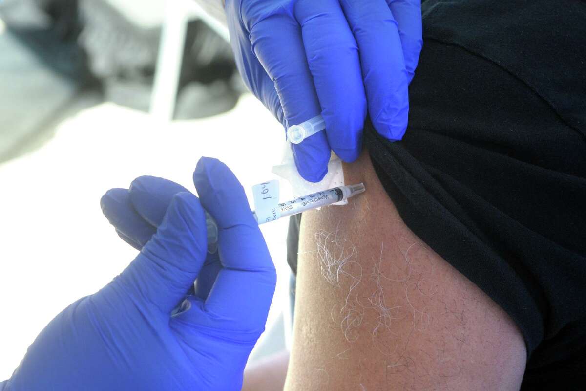 A COVID-19 vaccination is administered during a news conference in front of St. Vincent's Medical Center, in Bridgeport, Conn. Feb. 26, 2021. Nine black and Latino clergy members from various Bridgeport ministries received COVID-19 vaccinations at the Friday event.