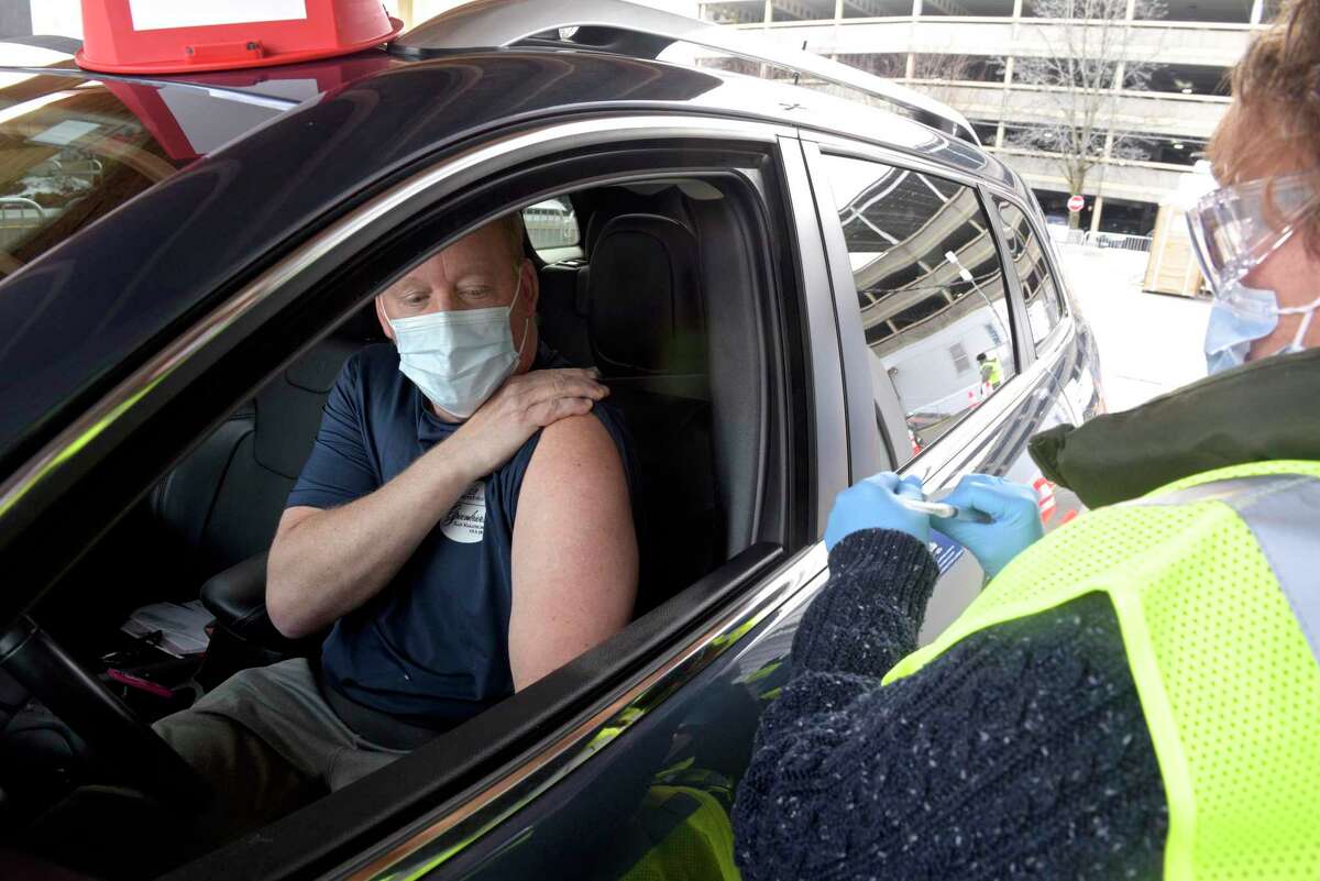 Thomas Kelm, of Bethel, waits to get his vaccination from Nancy Geary, an RN with Danbury Hospital, at Danbury's first mass COVID-19 vaccination site. The Community Health Center, Inc site will utilize six car lanes to serve 600 appointments a day at the Danbury Fair mall. Thursday, March 4, 2021, in Danbury, Conn.