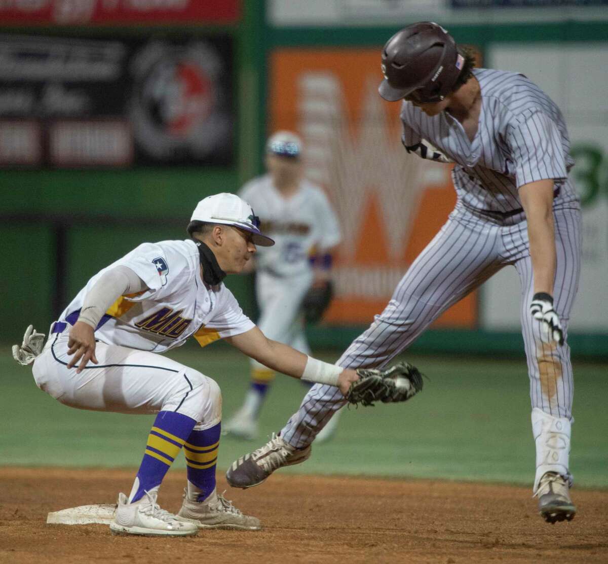 Lee High's Chase Shores tries to dodge the tag at second by Midland High's Jesse Hernandez 03/04/2021 night at Momentum Bank Ballpark during the Tournament of Champions. Tim Fischer/Reporter-Telegram
