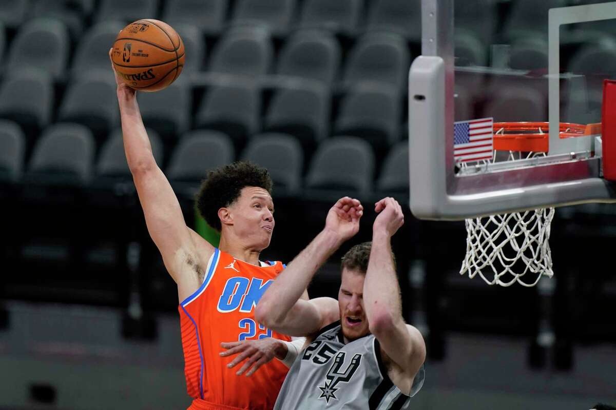 Oklahoma City Thunder center Isaiah Roby (22) scores over San Antonio Spurs center Jakob Poeltl (25) during the second half of an NBA basketball game in San Antonio, Thursday, March 4, 2021. (AP Photo/Eric Gay)