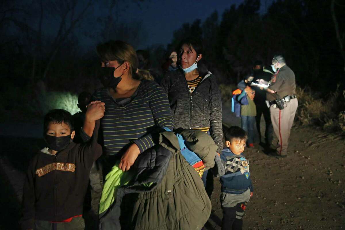 A Hidalgo County Precinct 3 Constable deputy guides migrant families to a U.S. Border Patrol processing area in Mission, Texas, Wednesday, Feb. 24, 2021. As the sun sets smugglers known as coyotes, started crossing mostly Central American families across the Rio Grande. The migrants surrendered to U.S. Border Patrol agents. Helping them out were Hidalgo County Precinct 3 Constable deputies.