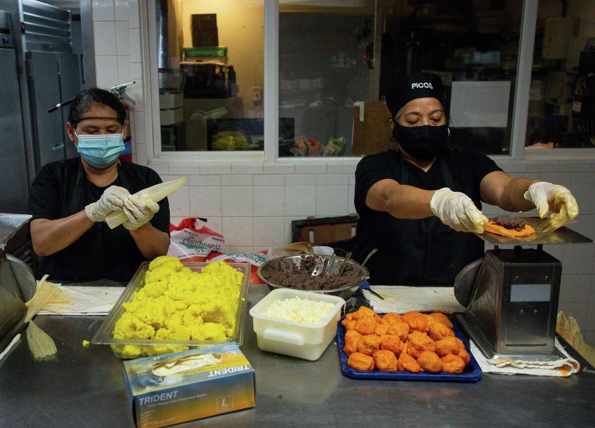 Caridad Gonzalez, left, and Magdalena Fonseca prepare tamales inside the Arnaldo Richard's Picos Restaurant kitchen on Thursday, March 4, 2021, in Houston. Following Gov. Greg Abbott's order lifting the statewide mask mandate and other COVID-19 restrictions, many Houston restaurants like Picos have vowed to keep those measures in place. Now they're getting threats.
