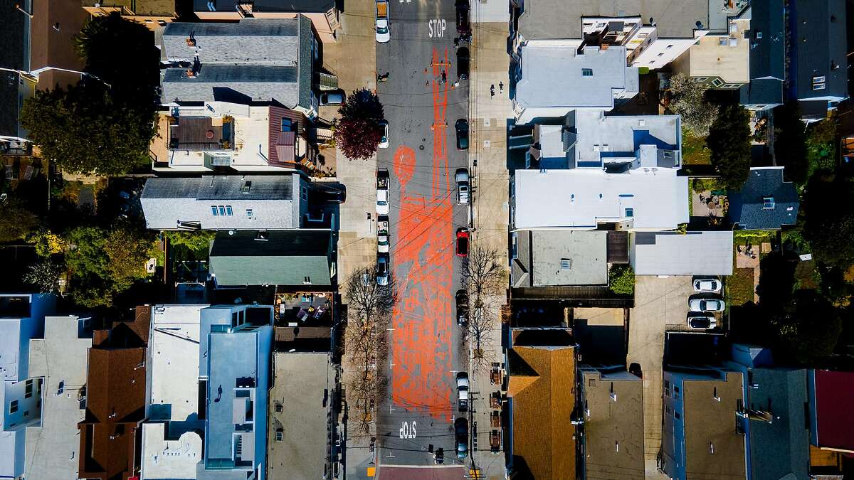 San Francisco artist Amos Goldbaum paints a mural on Sanchez Street between 24th and Elizabeth streets. The mural is a block long and is a depiction of San Francisco with Victorian houses and Sutro Tower.