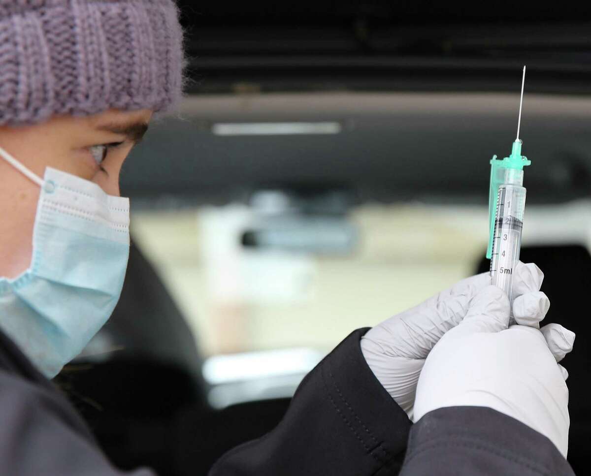 UTMB nurse practitioner Jennifer Young prepares the Pfizer vaccine in the driveway of their first home for the next few doses in Friendswood, Texas on Thursday, Feb. 18, 2021. Because of temperature, light exposure and timing for the vaccine, it's critical that they use their time efficiently.