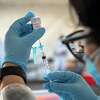 A health care worker Moderna COVID-19 vaccine in San Francisco, March 1, 2021. Some people are having delayed reactions to their first dose of a Covid vaccine, with their arms turning red, sore, itchy and swollen a week or so after the shot. (Mike Kai Chen/The New York Times)