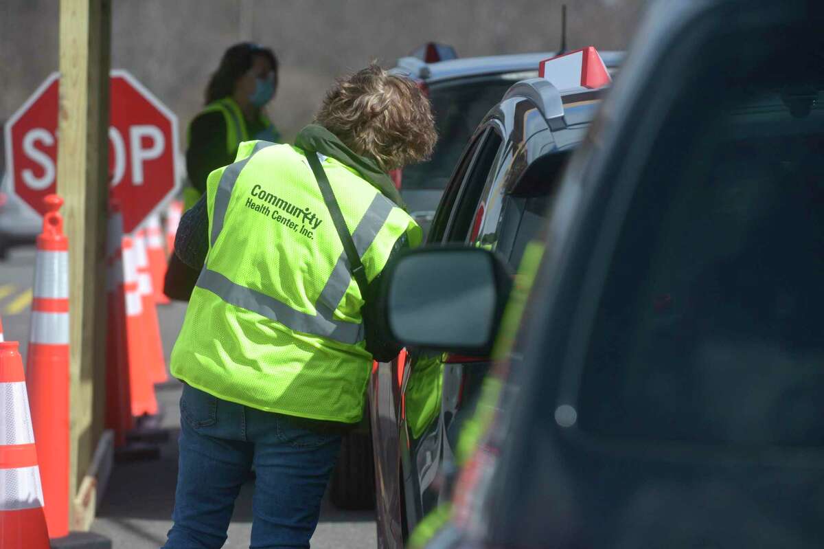 Nancy Geary, an RN with Danbury Hospital, takes information from a person waiting at Danbury's first mass COVID-19 vaccination site on Thrusday in Danbury.