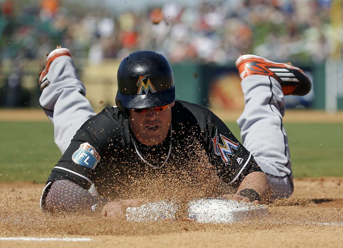 Miami Marlins' Justin Bour slides back to first base after an infield line drive was caught in the first inning of a spring training baseball game against the Detroit Tigers, Sunday, March 6, 2016, in Lakeland, Fla. (AP Photo/John Raoux)