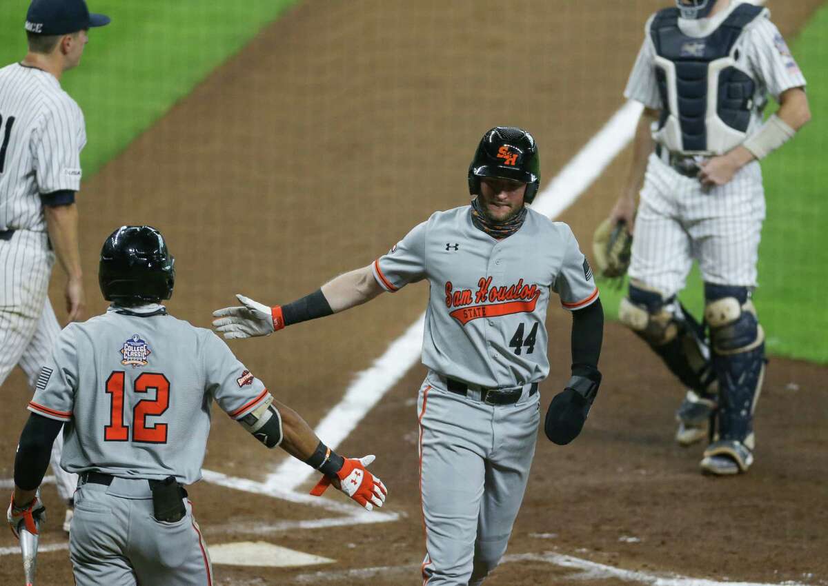 Sam Houston State first baseman Jack Rogers (44) celebrates after scoring off of a single hit by catcher Gavin Johnson (43) during the third inning of the Shriner's Hospitals for Children College Classic at Minute Maid Park Friday, March 5, 2021, in Houston.