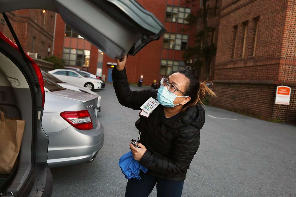 Juliet Palarca, Zuckerberg San Francisco General Hospital nurse, closes her trunk after parking at Zuckerberg San Franisco General Hospital at the start of her shift on Tuesday, June 16, 2020 in San Francisco, Calif.