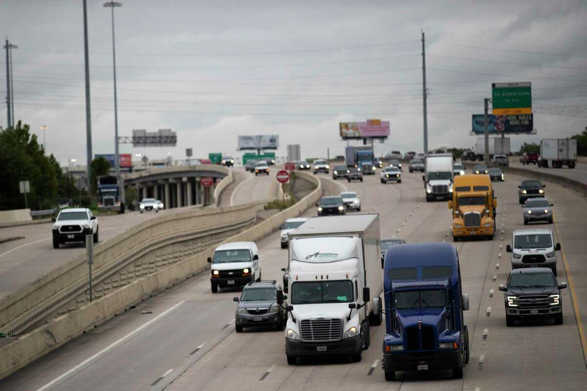 Trucks move along Interstate 10 near Patterson St. with the Houston skyline on the background on Sept. 24, 2020, in Houston.