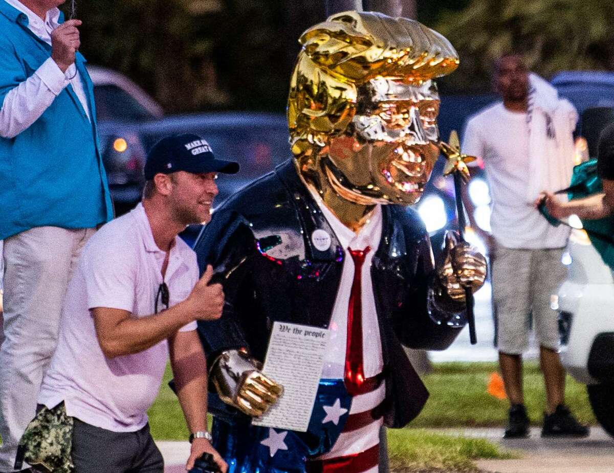 Supporters of former US President Donald Trump take pictures with a gold statue of him outside the hotel where the Conservative Political Action Conference 2021 (CPAC) was held in Orlando, Florida on February 28, 2021.