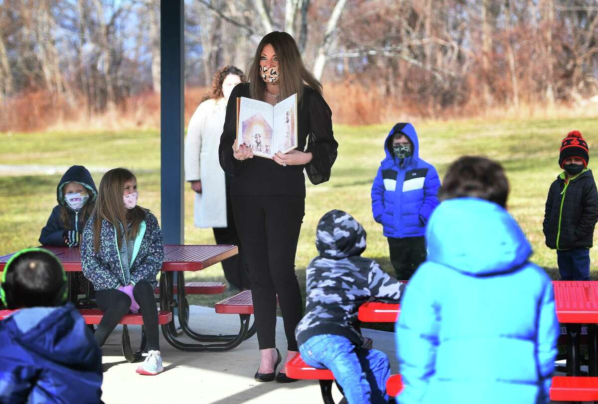 Shelton's Director of Curriculum Kristen Santilli reads to students in Tracey Sedlock's 1st grade class in the outdoor classroom at Mohegan School in Shelton on Jan. 19.